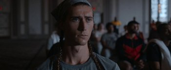 Movie still from “National Champions” (2021), directed by Ric Roman Waugh – A person with long braids; Close Up shot, Over the shoulder angle
