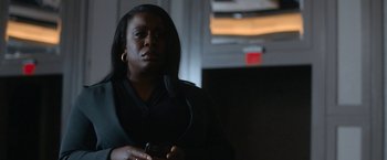 Movie still from “National Champions” (2021), directed by Ric Roman Waugh – A woman holding a cell phone while standing in a dark room; Close Up shot, Low angle