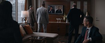 Movie still from “National Champions” (2021), directed by Ric Roman Waugh – A group of men standing in front of a television; Wide shot, Over the shoulder angle