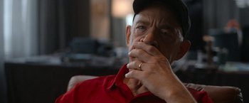 Movie still from “National Champions” (2021), directed by Ric Roman Waugh – An older man wearing a red shirt and a gold ring; Close Up shot, Over the shoulder angle