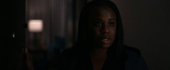 Movie still from “National Champions” (2021), directed by Ric Roman Waugh – A woman in a dark room looking at the camera; Close Up shot, Over the shoulder angle
