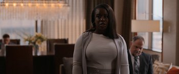 Movie still from “National Champions” (2021), directed by Ric Roman Waugh – A woman in a white shirt and a white jacket; Medium shot, Over the shoulder angle