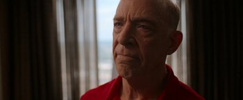 Movie still from “National Champions” (2021), directed by Ric Roman Waugh – An older man in a red shirt looks at the camera; Close Up shot, Low angle