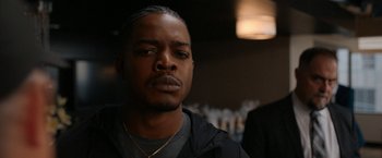 Movie still from “National Champions” (2021), directed by Ric Roman Waugh – A person wearing a black shirt; Close Up shot, Over the shoulder angle