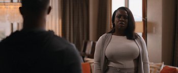 Movie still from “National Champions” (2021), directed by Ric Roman Waugh – A woman standing in front of a man in a room; Medium shot, Over the shoulder angle