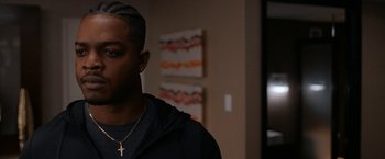 Movie still from “National Champions” (2021), directed by Ric Roman Waugh – A person with a cross necklace; Close Up shot, Over the shoulder angle