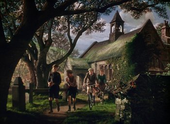 Movie still from “National Velvet” (1944), directed by Clarence Brown – A group of people riding bikes down a path; Wide shot, Low angle