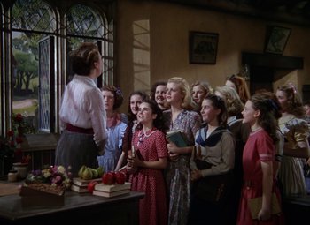 Movie still from “National Velvet” (1944), directed by Clarence Brown – A group of people standing around a table; Wide shot, High angle