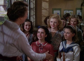 Movie still from “National Velvet” (1944), directed by Clarence Brown – A group of young people standing around a man; Medium shot, Over the shoulder angle