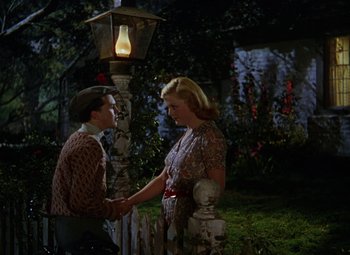 Movie still from “National Velvet” (1944), directed by Clarence Brown – A man and a woman standing next to a lamp post; Medium shot, High angle