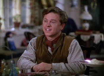 Movie still from “National Velvet” (1944), directed by Clarence Brown – A man sitting at a table in front of a plate of food; Medium shot, Over the shoulder angle