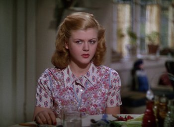 Movie still from “National Velvet” (1944), directed by Clarence Brown – A woman sitting at a table with a plate of food; Close Up shot, Over the shoulder angle