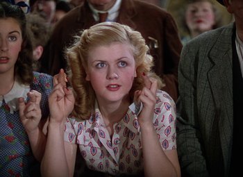 Movie still from “National Velvet” (1944), directed by Clarence Brown – A young woman is holding her hands up to her ears; Close Up shot, Low angle