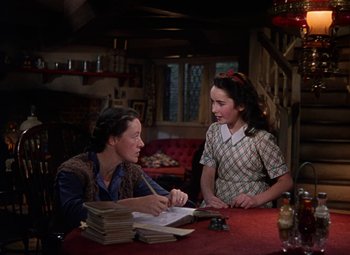 Movie still from “National Velvet” (1944), directed by Clarence Brown – A woman sitting at a table talking to another woman; Medium shot, High angle