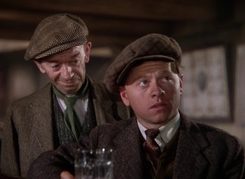 Movie still from “National Velvet” (1944), directed by Clarence Brown – Two men in suits and hats are sitting at a table; Close Up shot, Low angle