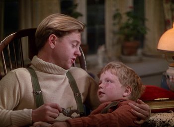 Movie still from “National Velvet” (1944), directed by Clarence Brown – A young man sitting next to a little boy; Medium shot, Over the shoulder angle