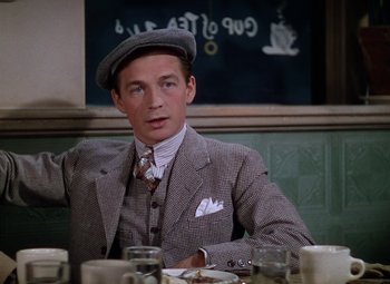 Movie still from “National Velvet” (1944), directed by Clarence Brown – A man sitting at a table in front of a chalkboard; Close Up shot, Over the shoulder angle