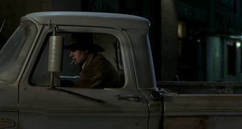 Movie still from “Near Dark” (1987), directed by Kathryn Bigelow – A man sitting in the drivers seat of an old pick - up truck; Medium shot, High angle