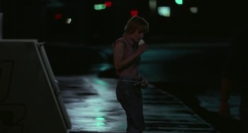 Movie still from “Near Dark” (1987), directed by Kathryn Bigelow – A woman standing on the side of a road at night; Wide shot, Over the shoulder angle