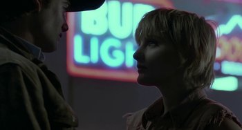 Movie still from “Near Dark” (1987), directed by Kathryn Bigelow – Two people standing next to each other in front of a neon sign; Close Up shot, Low angle