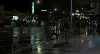Movie still from “Near Dark” (1987), directed by Kathryn Bigelow – A man standing on the side of the street at night; Wide shot, Low angle