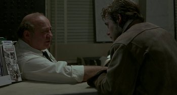 Movie still from “Near Dark” (1987), directed by Kathryn Bigelow – Two men sitting at a table arm in arm; Medium shot, Over the shoulder angle
