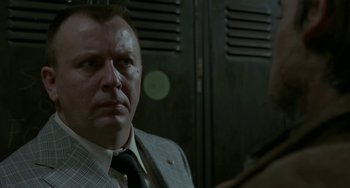 Movie still from “Near Dark” (1987), directed by Kathryn Bigelow – A person wearing a suit and a tie; Close Up shot, Over the shoulder angle