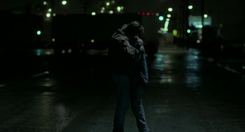 Movie still from “Near Dark” (1987), directed by Kathryn Bigelow – A man standing in the middle of the street at night talking on the phone; Wide shot, Low angle