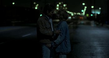 Movie still from “Near Dark” (1987), directed by Kathryn Bigelow – A man and a woman standing next to each other on the street; Medium shot, High angle