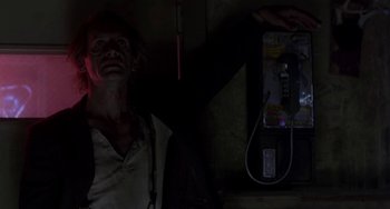 Movie still from “Near Dark” (1987), directed by Kathryn Bigelow – A man standing in front of a phone booth; Close Up shot, Low angle