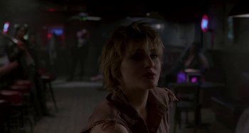 Movie still from “Near Dark” (1987), directed by Kathryn Bigelow – A woman with short blonde hair wearing a brown shirt; Close Up shot, Over the shoulder angle