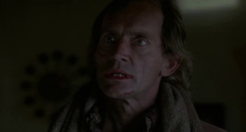 Movie still from “Near Dark” (1987), directed by Kathryn Bigelow – A person with a knife in his mouth; Close Up shot, Low angle