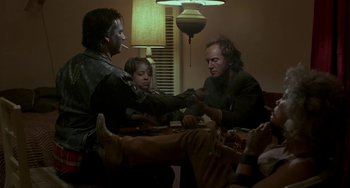 Movie still from “Near Dark” (1987), directed by Kathryn Bigelow – A group of people sitting around a table; Medium shot, Over the shoulder angle