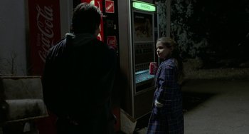 Movie still from “Near Dark” (1987), directed by Kathryn Bigelow – Two people standing in front of a vending machine at night; Medium shot, Over the shoulder angle