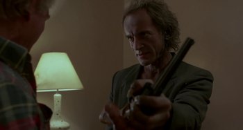 Movie still from “Near Dark” (1987), directed by Kathryn Bigelow – A man holding a violin in a room with a lamp; Close Up shot, Low angle