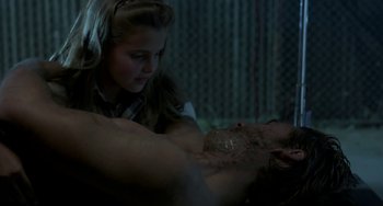 Movie still from “Near Dark” (1987), directed by Kathryn Bigelow – A young woman is looking at a shirtless man; Medium shot, Over the shoulder angle