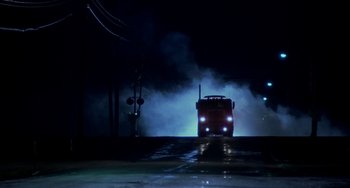 Movie still from “Near Dark” (1987), directed by Kathryn Bigelow – A truck driving down a street at night with fog; Extreme Wide shot, Low angle