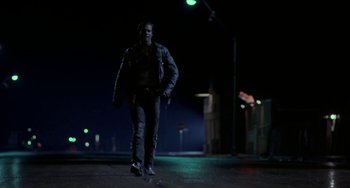 Movie still from “Near Dark” (1987), directed by Kathryn Bigelow – A man walking down a street at night; Wide shot, Low angle