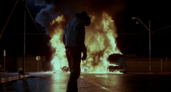 Movie still from “Near Dark” (1987), directed by Kathryn Bigelow – A man standing in front of a burning car; Wide shot, Low angle