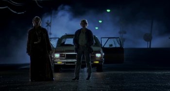 Movie still from “Near Dark” (1987), directed by Kathryn Bigelow – A man standing in front of a car at night; Wide shot, Low angle