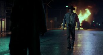 Movie still from “Near Dark” (1987), directed by Kathryn Bigelow – A man wearing a hat walking down a street; Wide shot, Low angle
