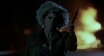 Movie still from “Near Dark” (1987), directed by Kathryn Bigelow – A woman in a white wig holding a knife; Close Up shot, Low angle