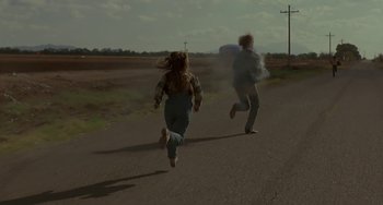 Movie still from “Near Dark” (1987), directed by Kathryn Bigelow – A couple of people running down a street; Wide shot, High angle