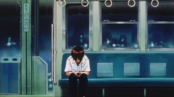 Movie still from “Neon Genesis Evangelion: Death & Rebirth” (1997), directed by Tensai Okamura – A person sitting on a bench on a train; Wide shot, Low angle