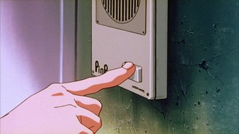 Movie still from “Neon Genesis Evangelion: Death & Rebirth” (1997), directed by Tensai Okamura – A hand that is pointing to a button on a wall; Extreme Close Up shot, High angle