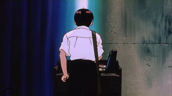 Movie still from “Neon Genesis Evangelion: Death & Rebirth” (1997), directed by Tensai Okamura – A man standing in front of an electronic keyboard; Medium shot, Low angle