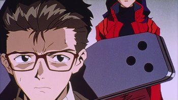 Movie still from “Neon Genesis Evangelion: Death & Rebirth” (1997), directed by Tensai Okamura – A man's face with a laptop in front of him; Close Up shot, Low angle