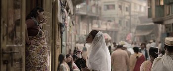 Movie still from “Gangubai Kathiawadi” (2022), directed by Sanjay Leela Bhansali – A woman with a veil on her head holding a purse; Medium shot, Over the shoulder angle