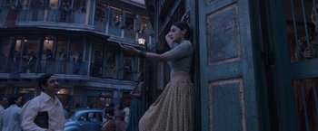 Movie still from “Gangubai Kathiawadi” (2022), directed by Sanjay Leela Bhansali – A woman leaning up against a wall in front of a building; Wide shot, Low angle