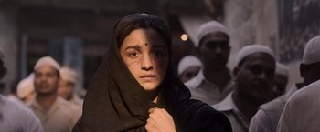 Movie still from “Gangubai Kathiawadi” (2022), directed by Sanjay Leela Bhansali – A woman with a black head scarf and a man behind her; Close Up shot, Low angle